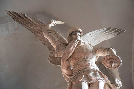 Une statue de l'archange Michel en pierre blanche vue d'en dessous et en gros plan, majestueux et imposant, il impose le respect. Souvenir du Mont Saint-Michel en Normandie en France