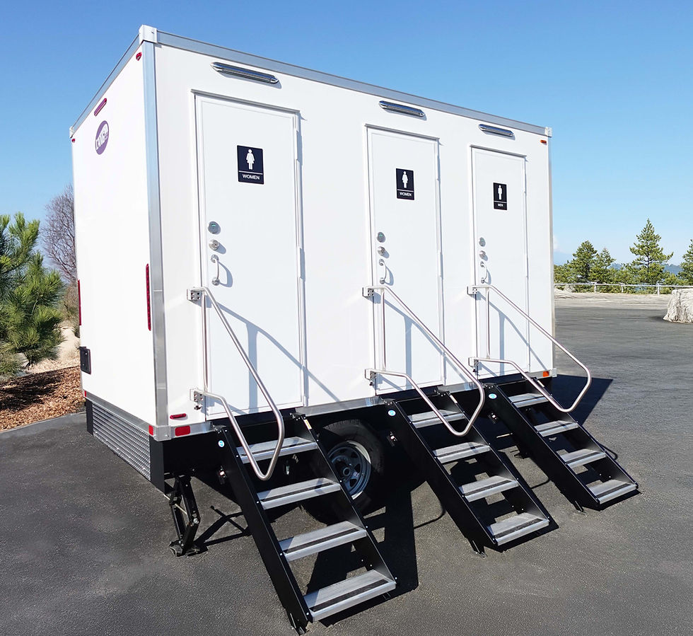 Eye-level view of a luxury restroom trailer parked on a green lawn