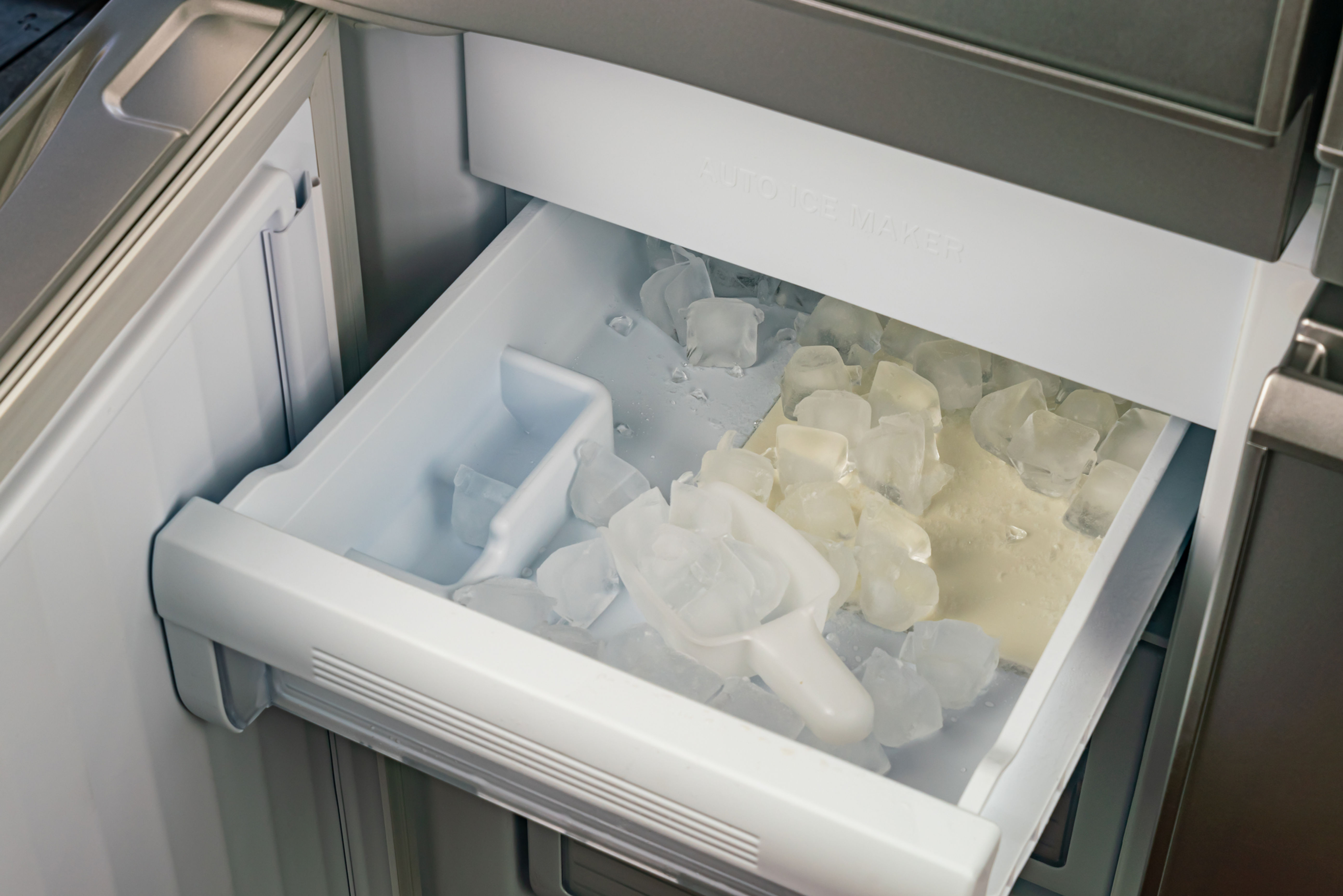 Open ice maker drawer with ice