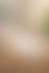 Bedside table with candle and flowers featuring a card that reads “I Am Grateful For: Today” in a calm, sunlit bedroom.