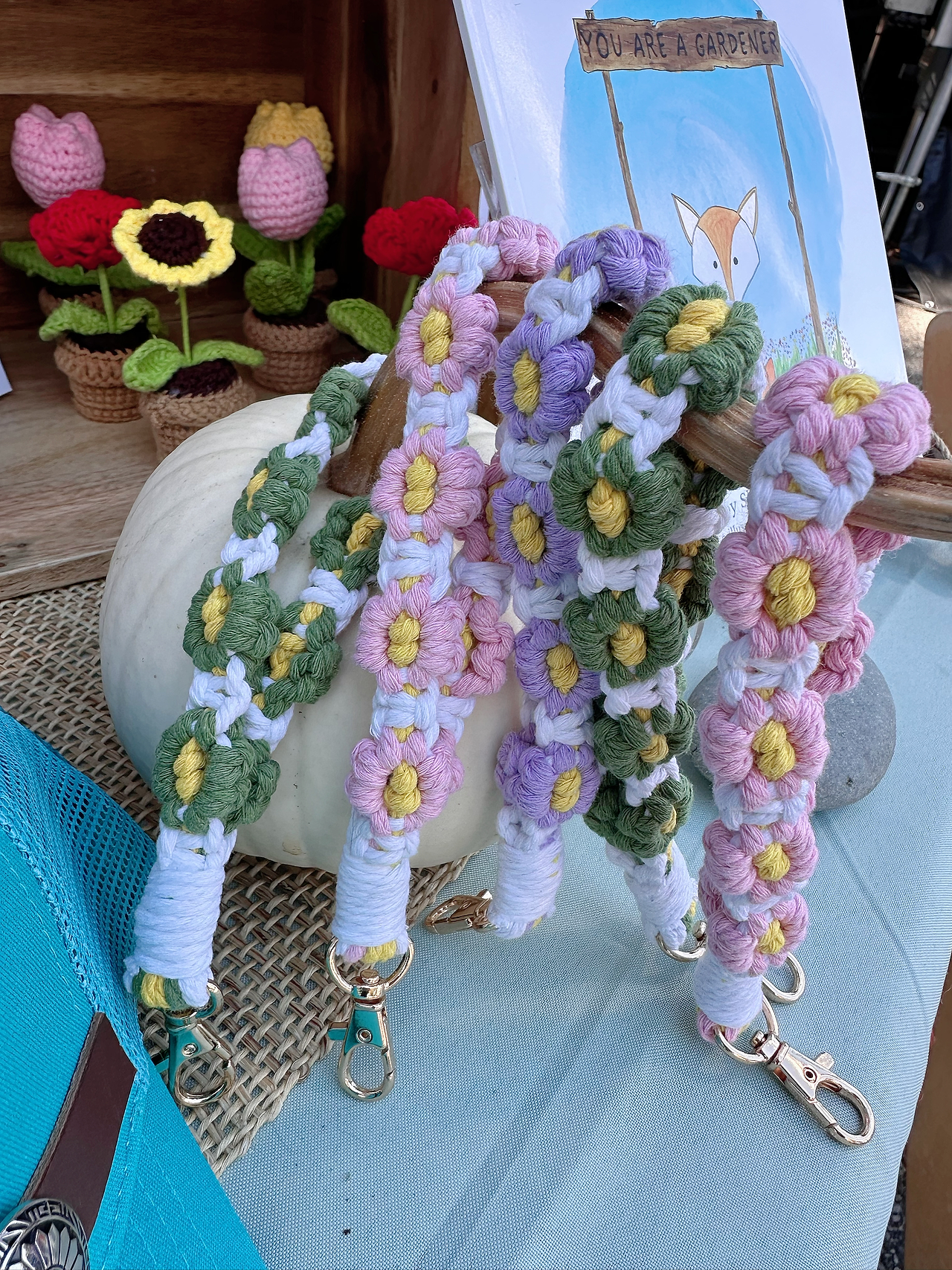 Close-up of handmade macramé flower keychains and crocheted flower décor at the You Are a Gardener® booth during Bottle Hill Day.