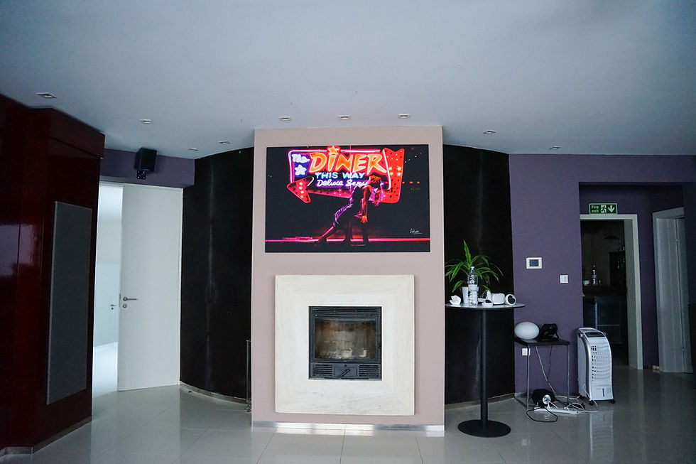 Large neon city photograph above fireplace in luxury villa