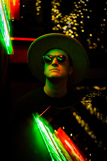 French DJ photographed in dramatic neon light with a double-exposure effect