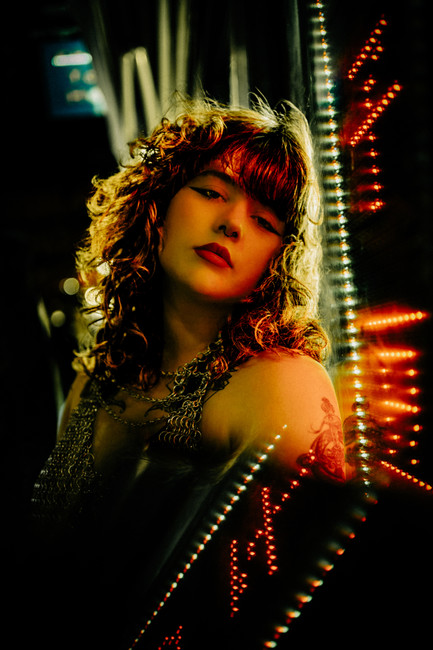 Cinematic portrait of Rhea Thompson of Tailgunner in neon light with an editorial blurred effect