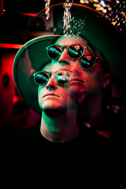 Portrait of a French DJ wearing sunglasses with a layered double-exposure effect
