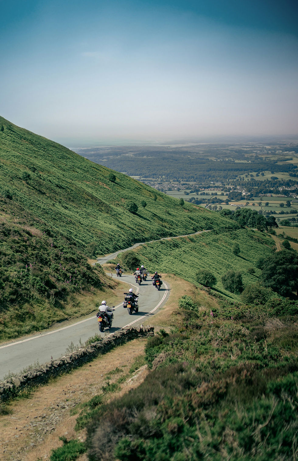 group of motorcycles riding on a curvy road