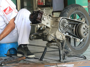 mechanic working on a motorcycle engine