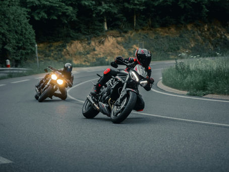 two riders on motorcycles on a winding road