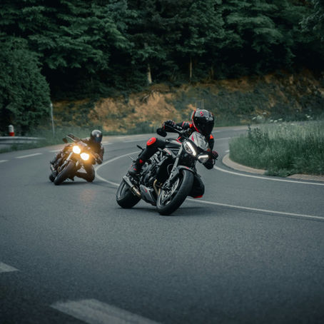 two riders on motorcycles on a winding road