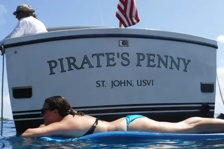 42-foot power cruiser anchored in turquoise water with guests relaxing on board in the U.S. Virgin Islands