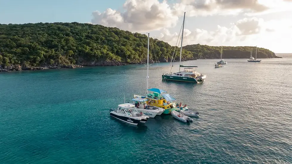 Private boat cruising at sunset in the U.S. Virgin Islands with orange and pink sky over calm Caribbean water