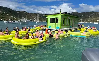 Boat anchored in turquoise water with guests enjoying Lime Out floating taco bar.