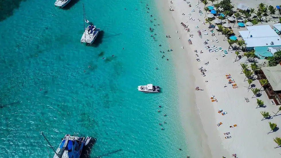 Private powerboat anchored in White Bay Jost Van Dyke with turquoise Caribbean water and beach bars along the shore