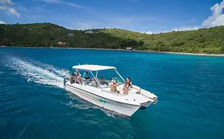 Private power catamaran cruising at sunset in Pillsbury Sound with orange and pink Caribbean sky