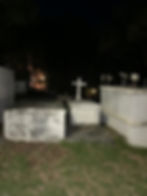 Nighttime walking tour in Cruz Bay with a guide sharing ghost stories near historic landmarks.