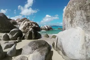 Visitors hiking through the granite boulders and turquoise pools at The Baths on Virgin Gorda.