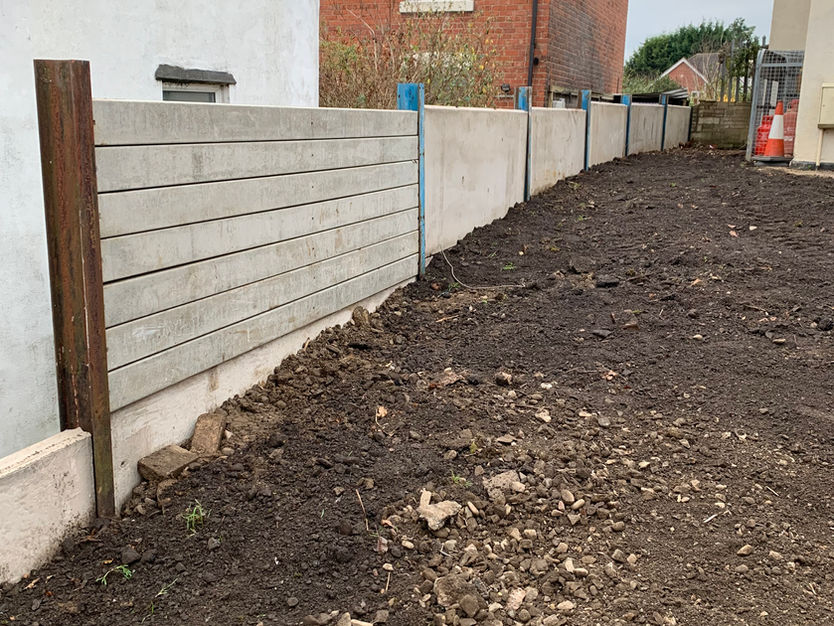 Retaining wall created for concrete panel fence