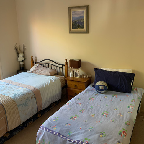 Two mismatched single beds in bedroom