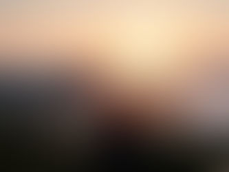 hiker looking over mountain to sunset