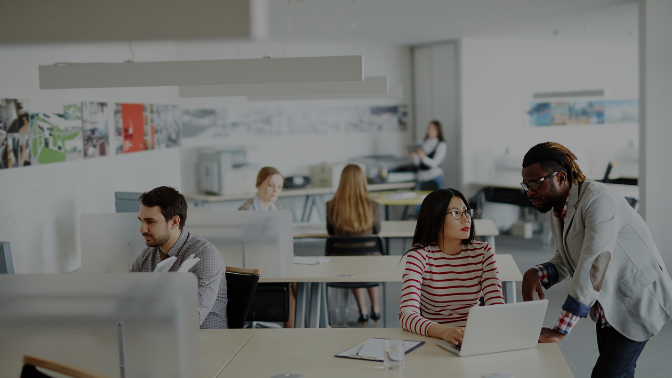 white, open concept office with 6 employees scattered at desks.