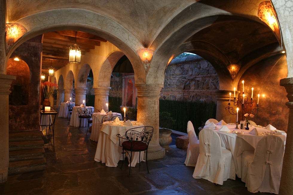 La Cueva restaurant interior at Mesón Panza Verde with colonial stone arches, candlelit dining tables, and vaulted ceilings - Tenedor de Oro fine dining in Antigua Guatemala