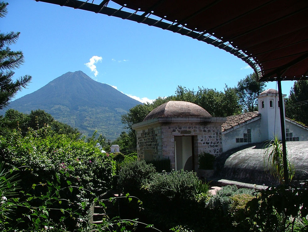 Rooftop terrace view of Agua volcano from Mesón Panza Verde boutique hotel in Antigua Guatemala - colonial architecture with lush gardens and volcano views