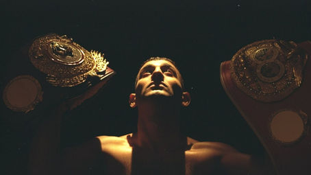 Prince Naseem Hamed holding multiple world title belts during his featherweight boxing career
