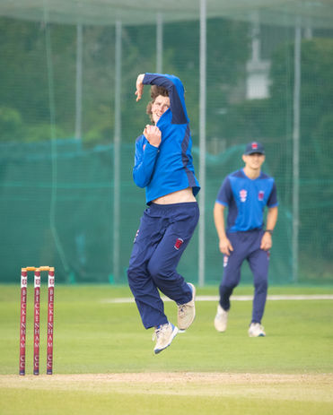Cricket bowler delivers ball during a match