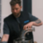 Ashley Poole installing ducting piece for roastery emissions solution
