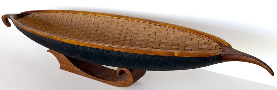 Thumbnail: Wooden waka with a woven rimu interior, black corded hull, and a rimu stand - larger image.
