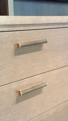 Overflater i beiset og lakkert eikefinér med håndtak i brunt skinn og messing