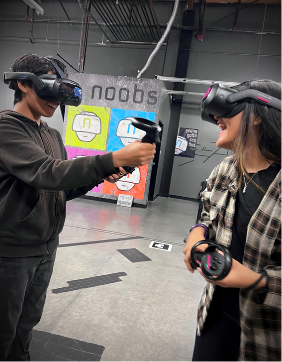 a mother and son laugh as they see each other in a free roam VR escape room at they play wireless virtual reality together at noobs VR in redlands, ca.