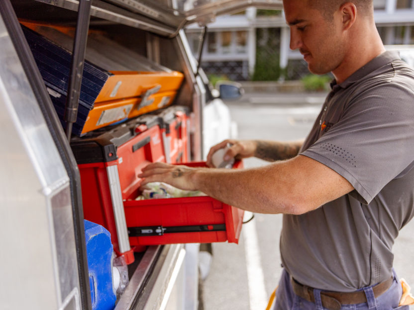 Professional electrician service vehicle and organised toolbox with tools and supplies.