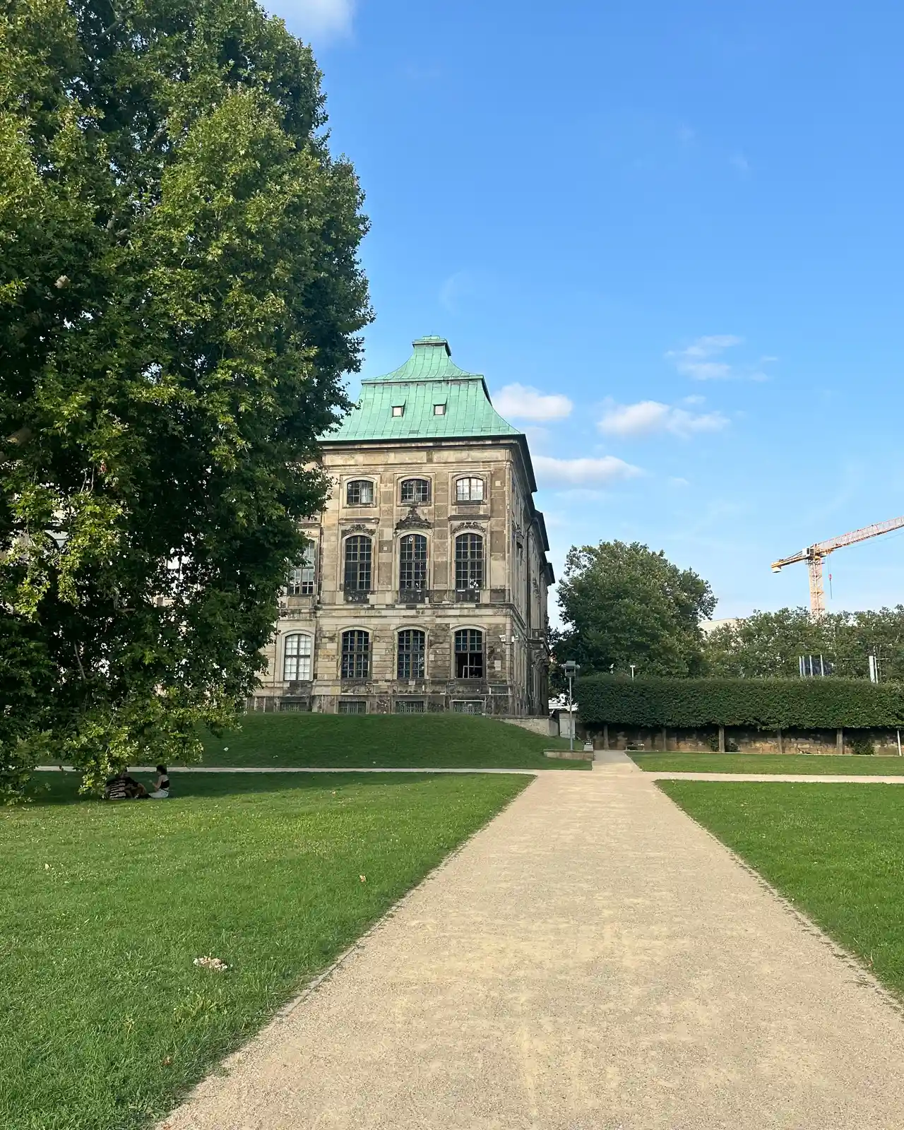 green gardens with an old building in dresden, germany photographed on iphone 14 pro max