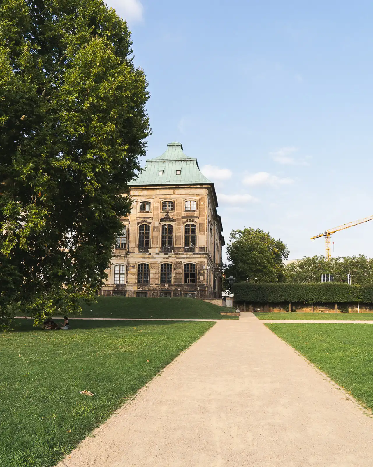 green gardens with an old building in dresden, germany photographed using sony alpha 7iii