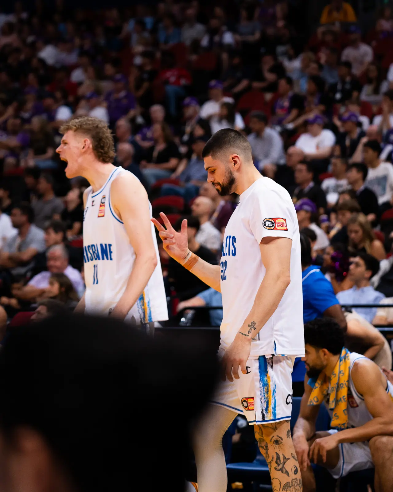 brisbane bullets nbl basketball players celebrating- matt johns and rocco zikarsky
