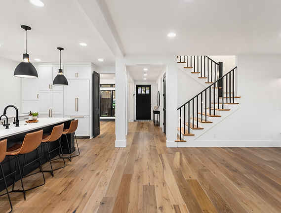 Kitchen and living room interior in new luxury home with open concept floor plan. Features