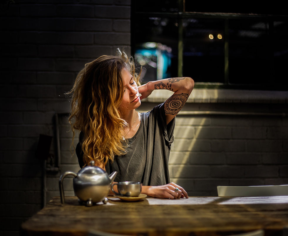 A woman sitting at a table massaging her neck.