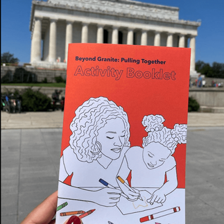 An image of an activity book with a red cover and two black girls coloring