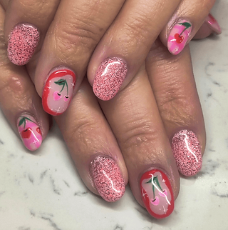 a set of painted human nails with cherrys and pink sparkles