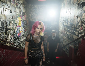 Portrait femme cheveux roses tenue résille noire escalier graffiti