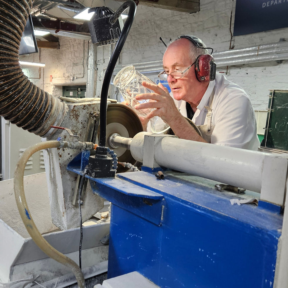 A master craftsman skillfully shapes glass on a lathe with precision.