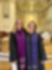 Jaime Clark-Soles, dressed in her clergy robe and a purple stole, stands alongside Rev. Annette Owen near the front of a church sanctuary, with a piano in the background.