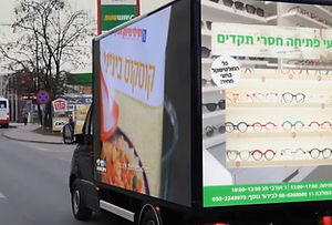 משאית הפרסומת מתגלגלת ברחוב עם משחק מסחרי