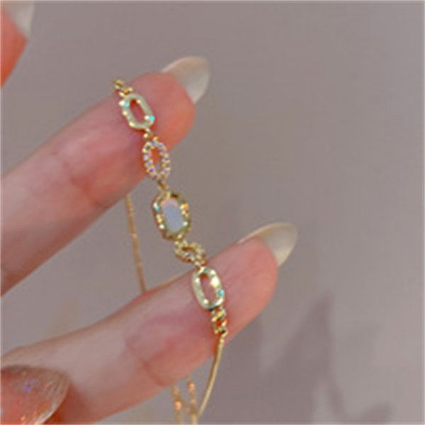 Thumbnail: Elegant red crystal heart bracelet with colorful zircon stones on a gold metal link chain.