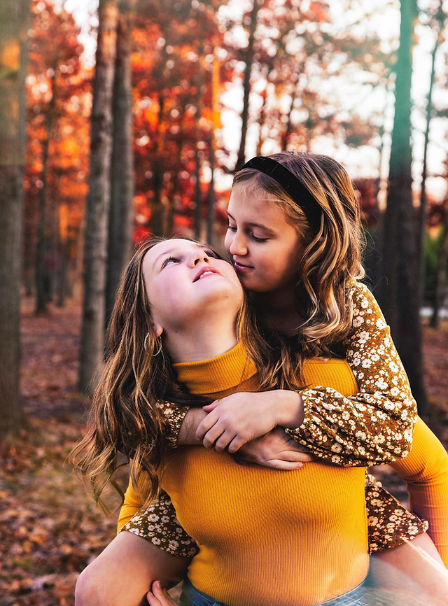 Two sisters posing at a South Jersey park for a family photography session.