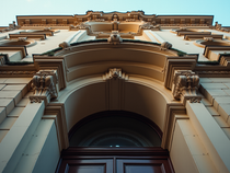 Historische Gebäudefassade mit kunstvoll verzierten architektonischen Elementen aus der Augenperspektive betrachtet.