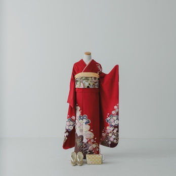 鮮やかな赤色のシンプルな着物に、裾と袖のたもとに大きな花柄のある粋な振袖