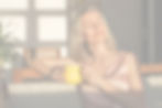 Attractive happy middle aged woman is sitting on sofa in living room. Smiling adult lady