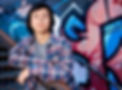 Senior guy standing in front of a graffiti wall on rusted out stairs